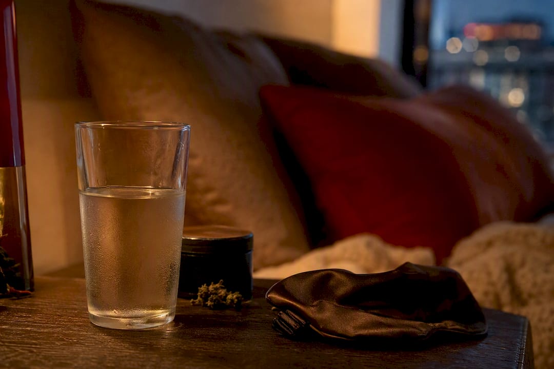 Water glass and herbal container on nightstand