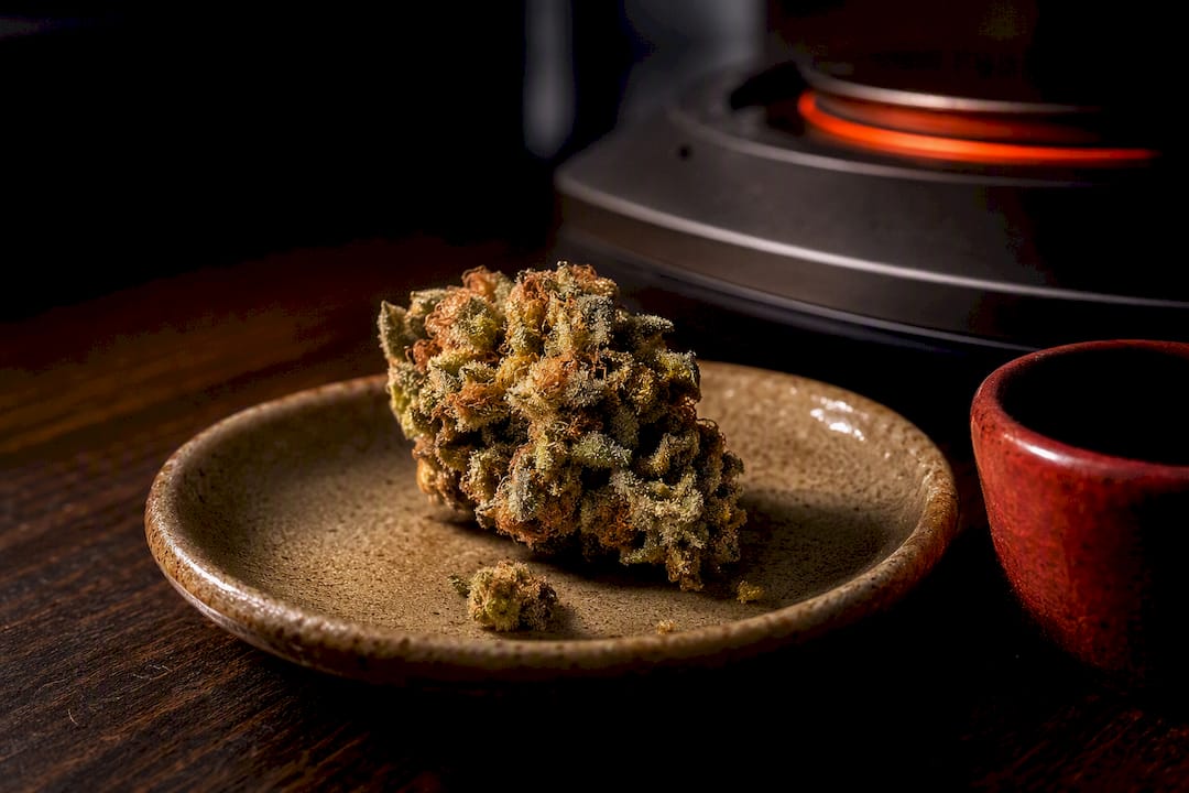 Resin-coated cannabis fragment under gentle heat